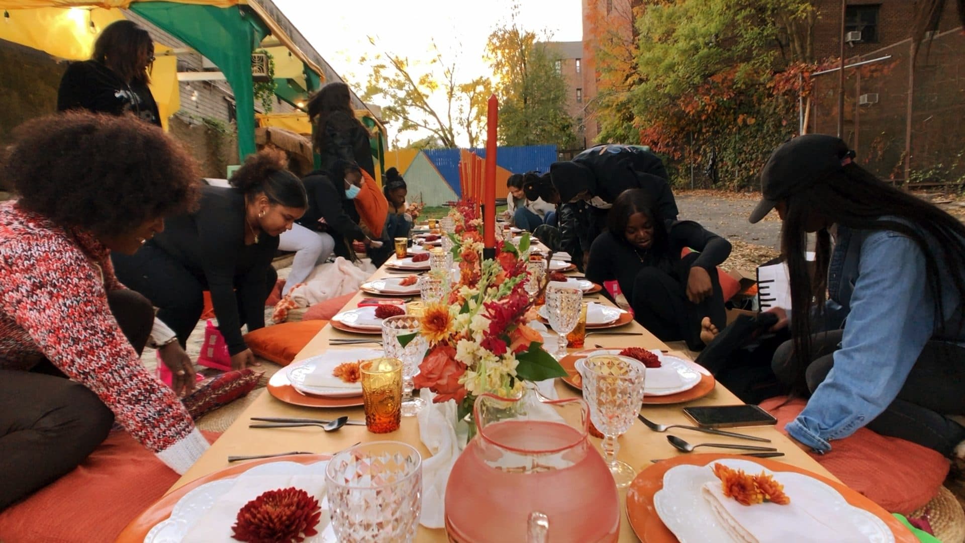 An outdoor brunch table set with string lights for a celebration.