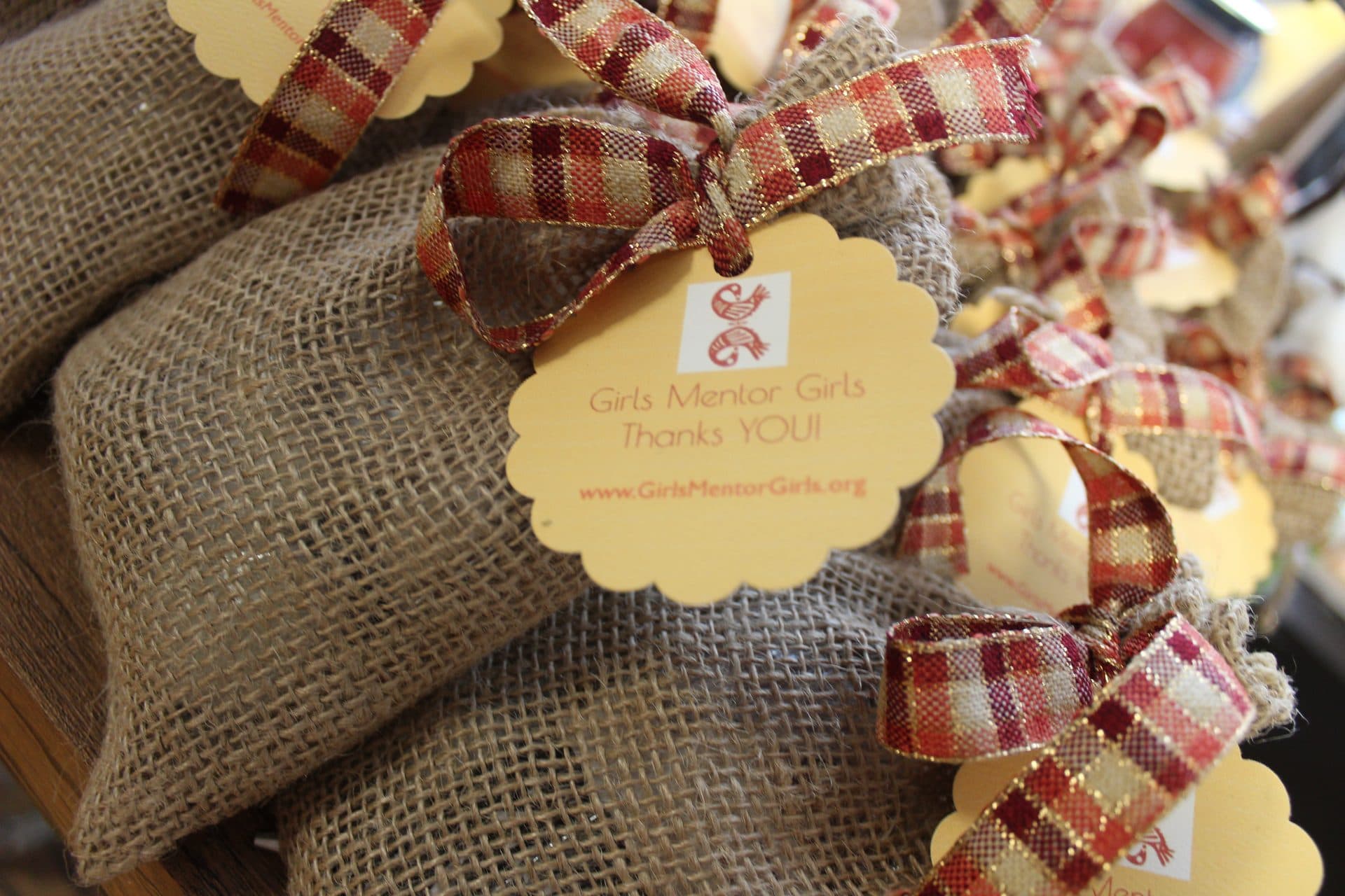 Handmade gift bags with ribbon and thank-you tags from Girls Mentor Girls.