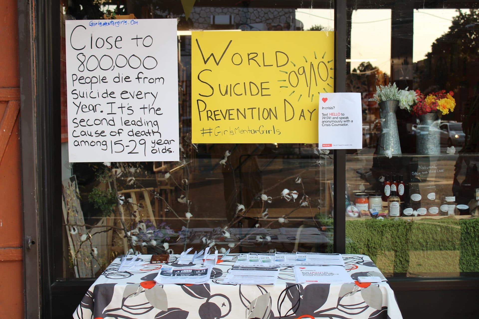 An outdoor community outreach table with informational signage.