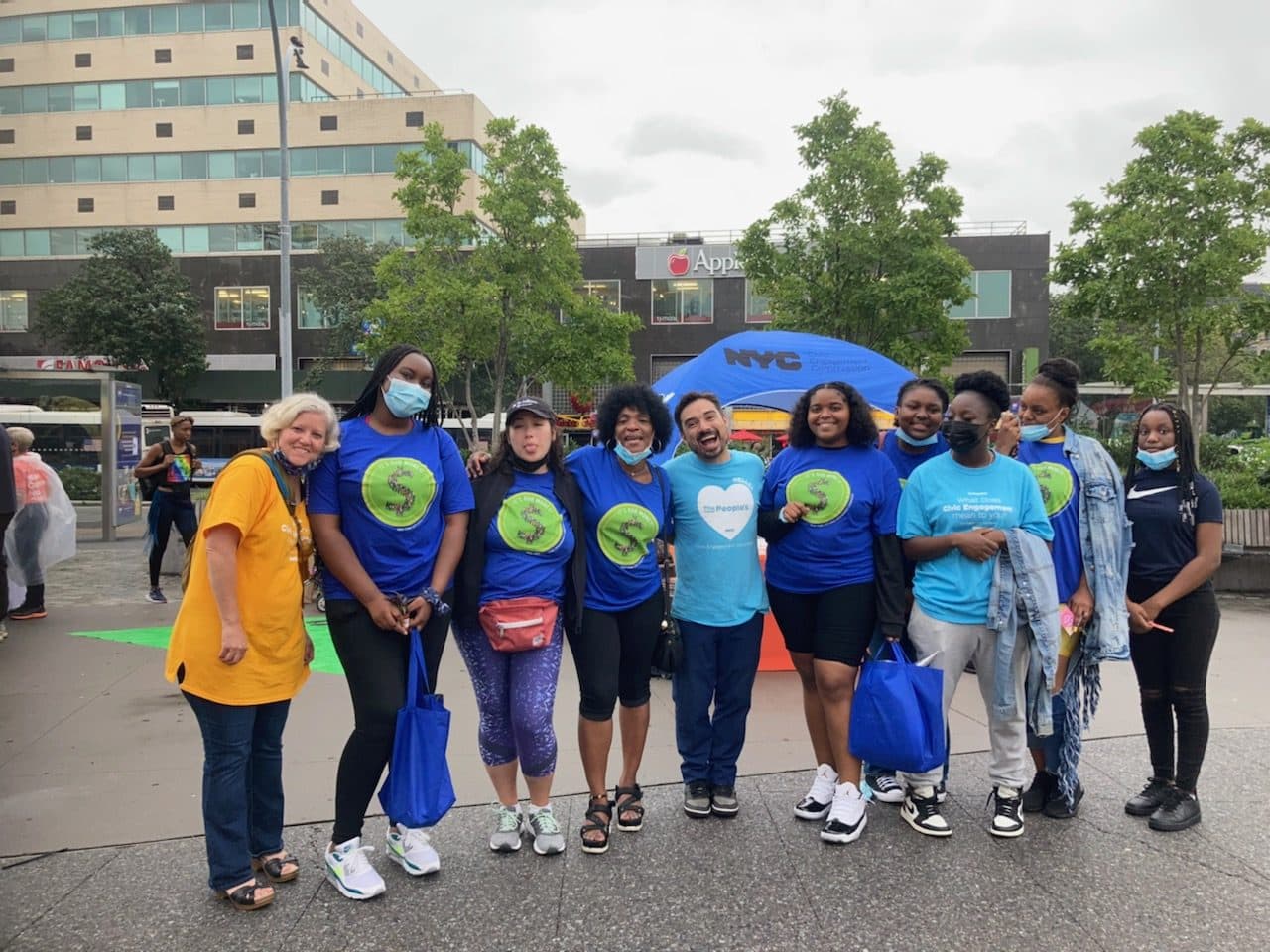 A group of GMG members walking together outdoors in matching t-shirts.