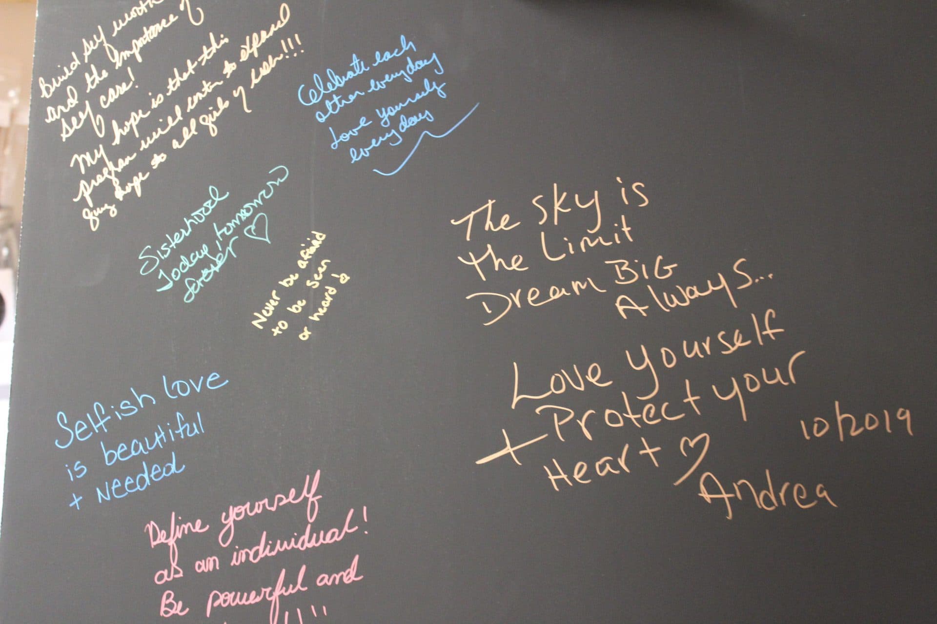 A chalkboard covered in handwritten affirmations.
